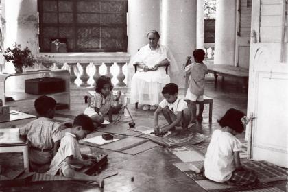 María Montessori observa el trabajo autónomo de niños y niñas en una escuela Montessori
